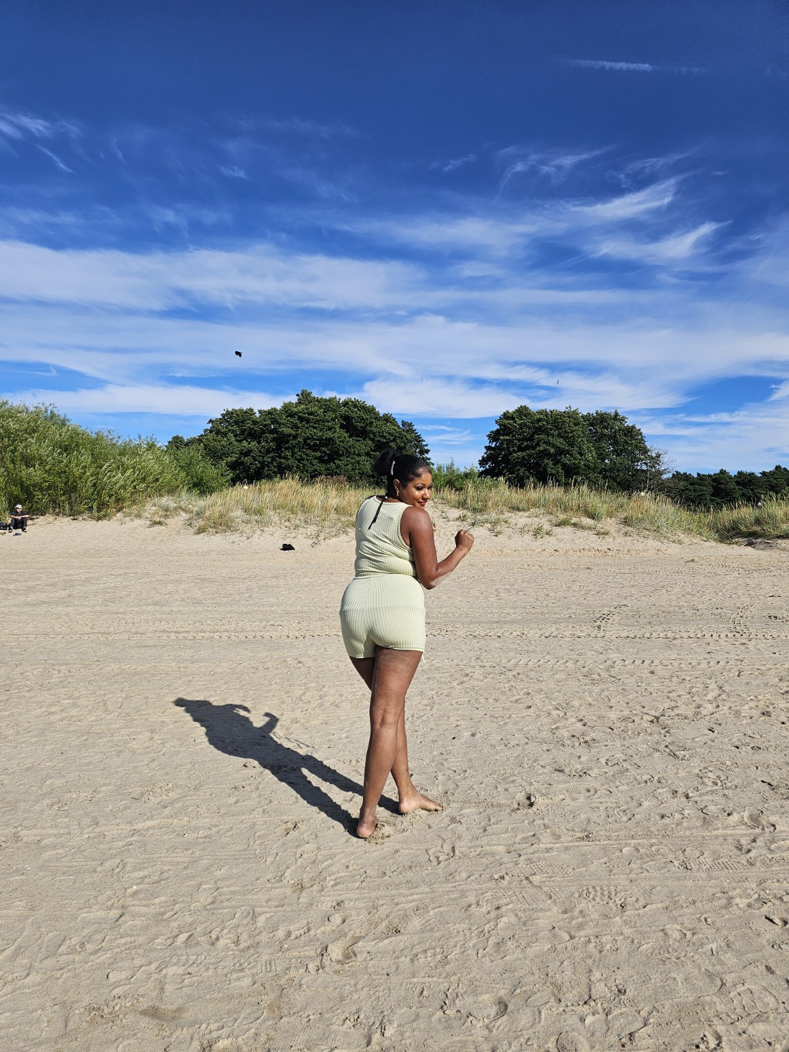 Jade walking forward on a bright beach